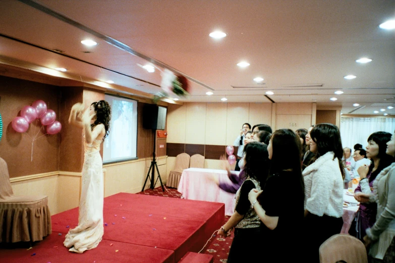 a woman standing on a red carpet holding up pink balloons