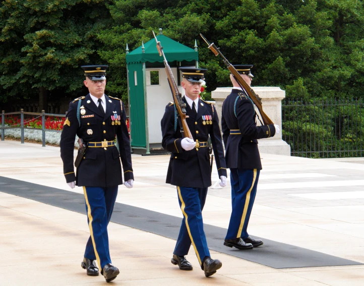 three male soldiers marching with their bags full of papers