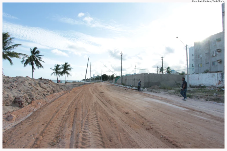 a person on a bike in the middle of a dirt road