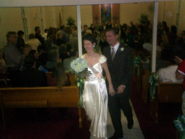 a man and a woman walking down a aisle next to each other