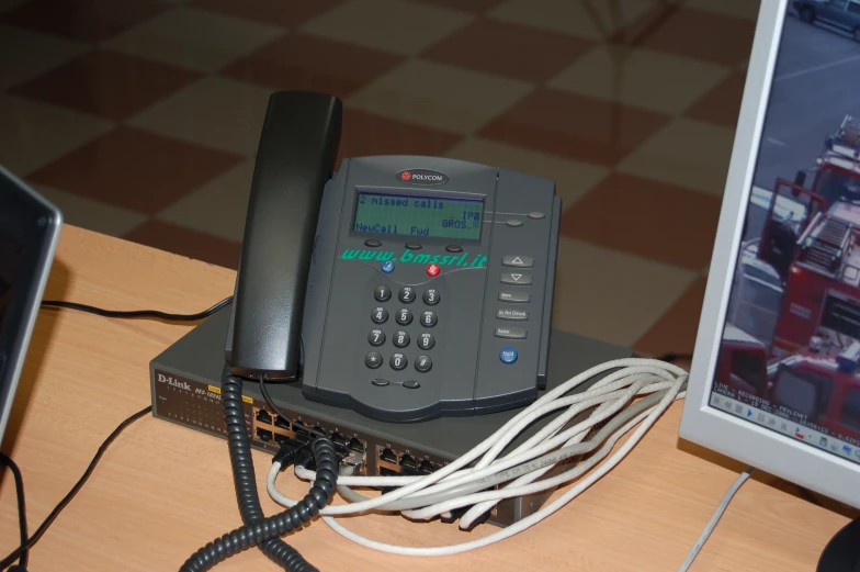 a desk with two phones and cords on it