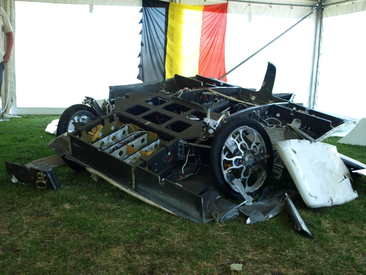 a car on display in the grass, being worked on