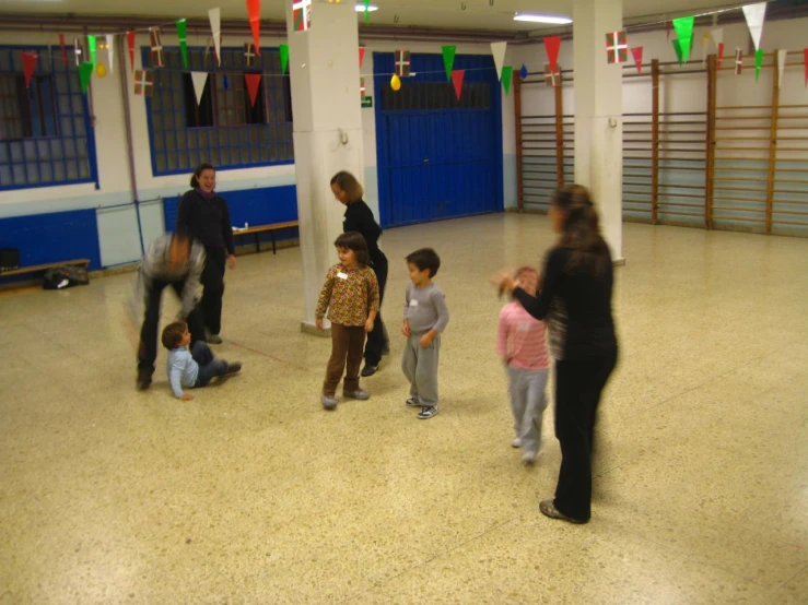 adults and children playing with an adult horse in a room