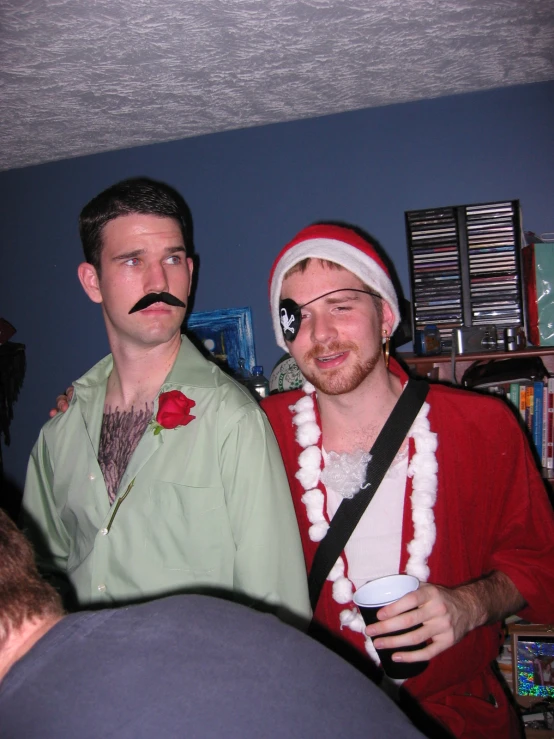 two men dressed as santa clause in a living room