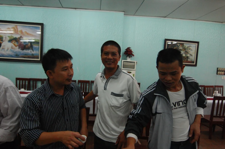 four guys standing around together playing nintendo wii