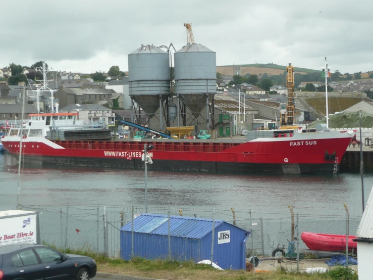 a large red boat in a marina next to buildings