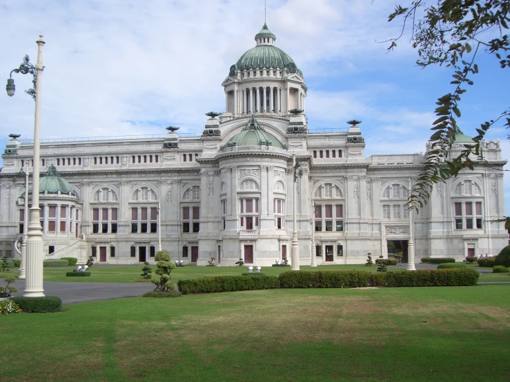 an ornate building with large windows and a lawn in front