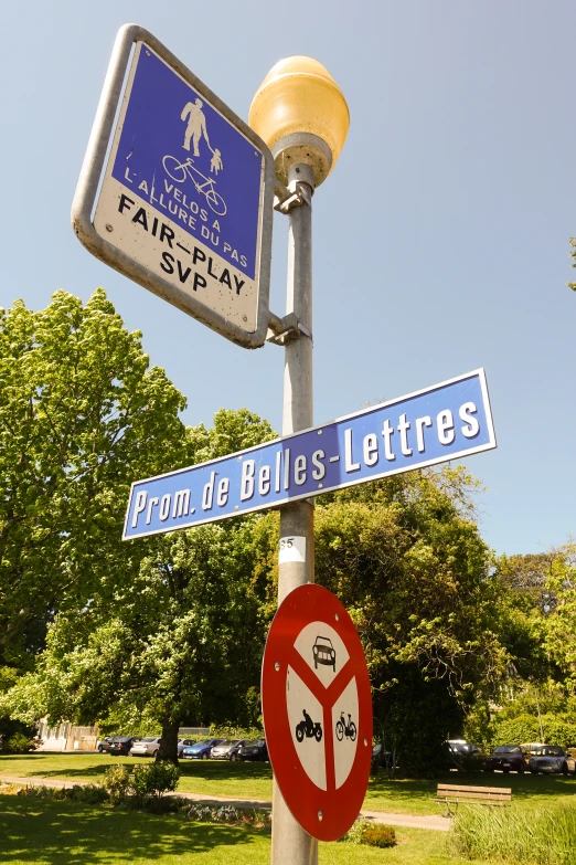 street sign on pole near lamppost in urban setting