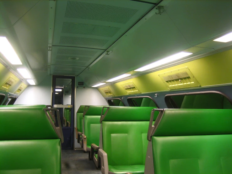 the interior of a train car with bright green seats