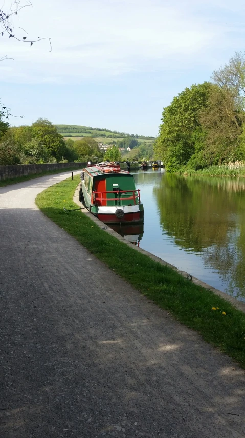 two boats parked along a bank next to the side of a road