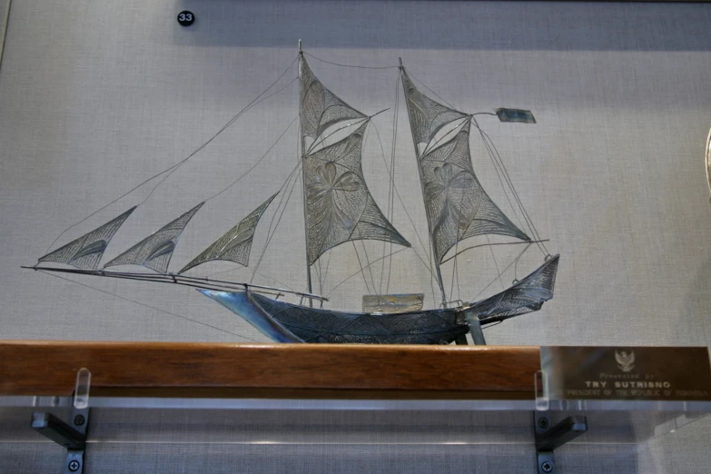 a model of a boat on display with metal hooks