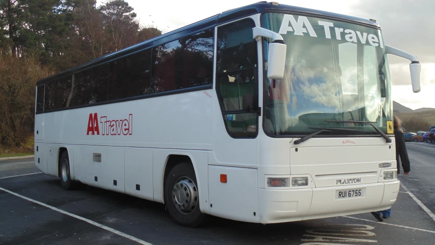 the front of a white bus in a parking lot