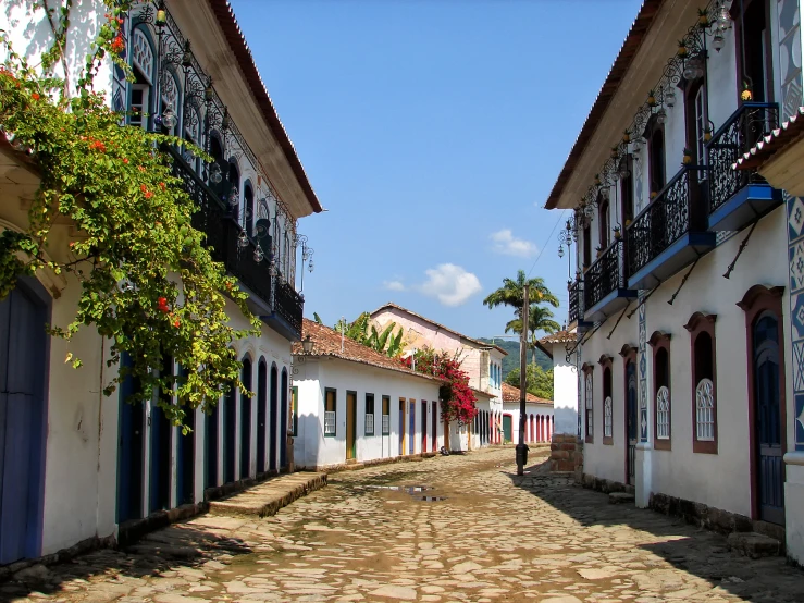 an old street that looks narrow with a building with decorative designs and balconies