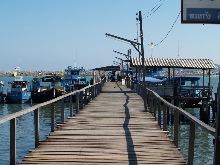 a wooden dock with many boats docked in the water