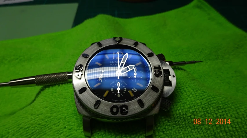 a watch on a green cloth showing time