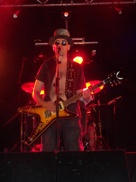 a male in a cowboy hat is playing a guitar