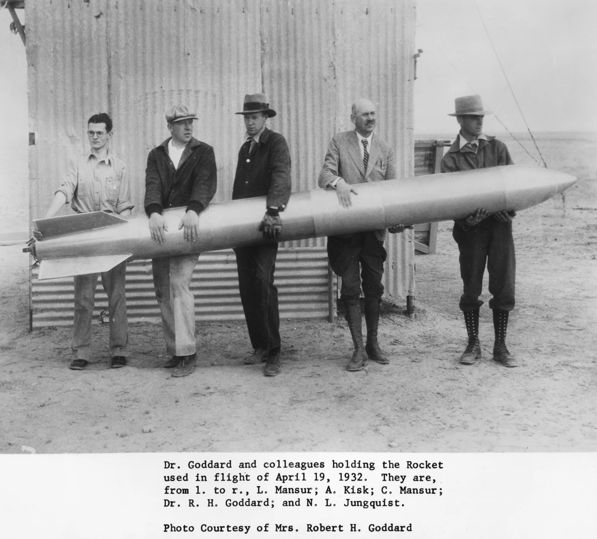 men in suits standing next to an airplane