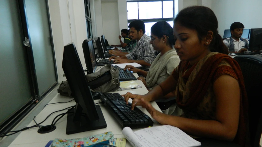 a woman sitting at a desk working on a computer