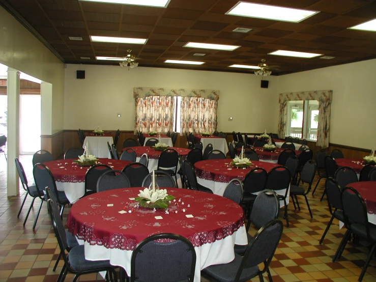 banquet room with red tablecloth and white table cloths and decorations