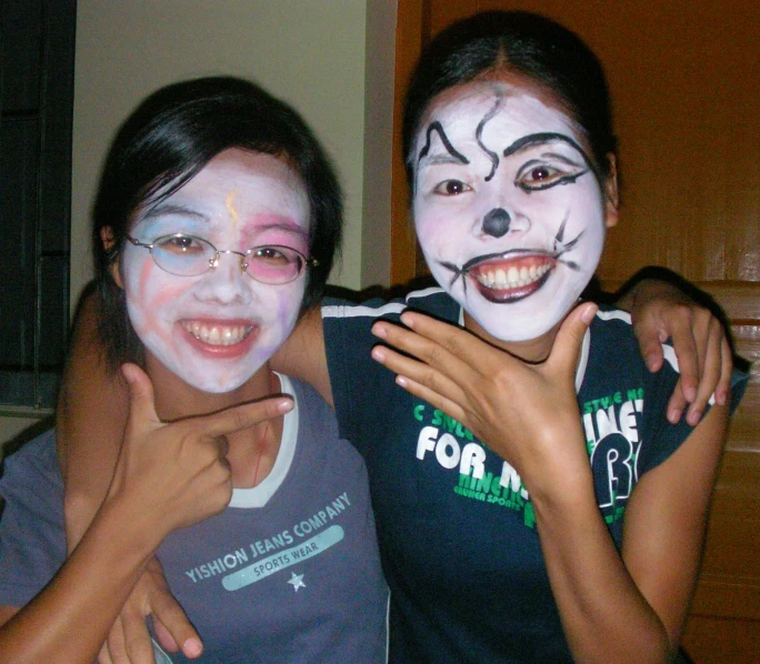 two s are posing with their face paint