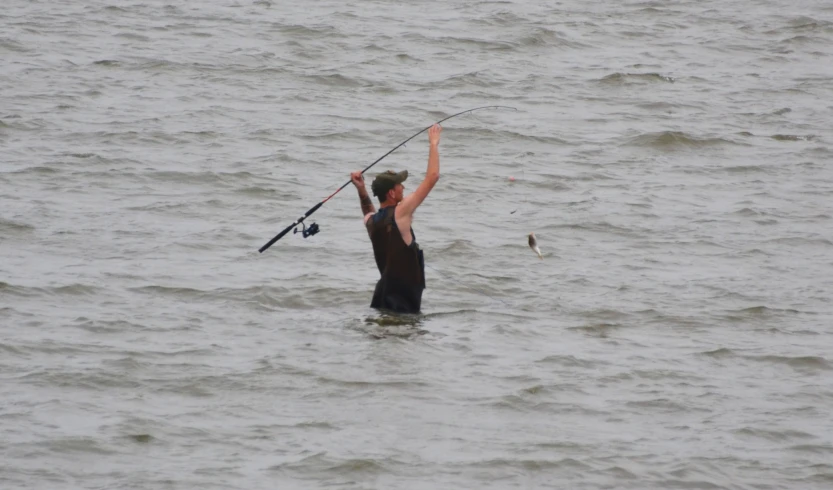 a person in the ocean holding a fishing pole