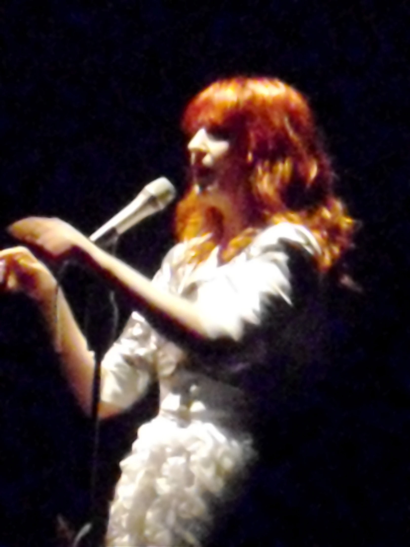 a woman with red hair, a microphone and an expression of disbelief