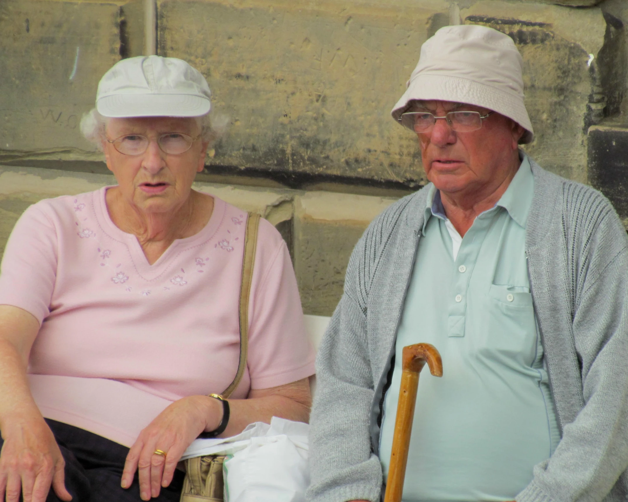 two people sit on a bench next to one another