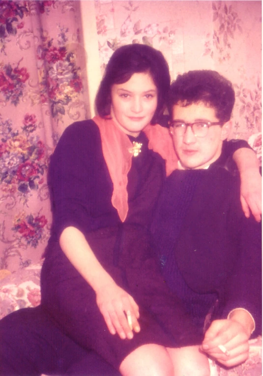 an old po of a woman sitting on the lap of a man