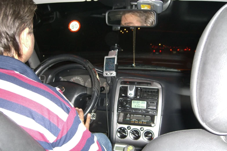 the driver uses a digital device to navigate a vehicle's dashboard