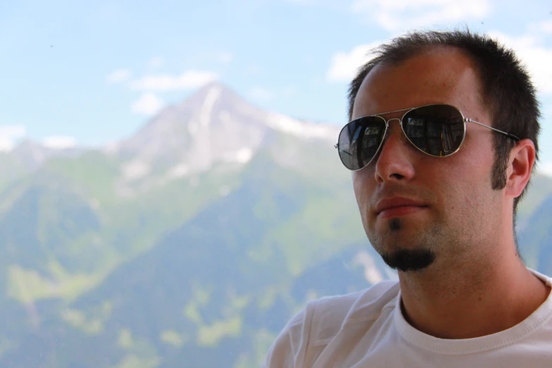 a man in the mountains wearing his sunglasses