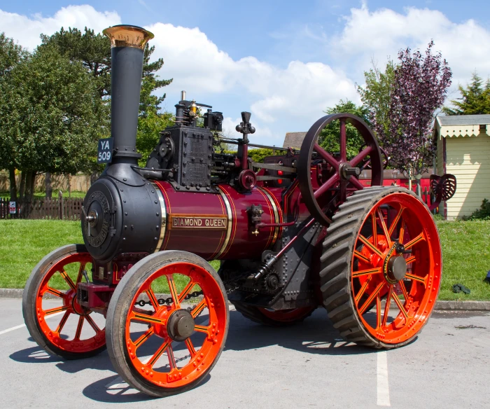 the red steam engine is parked outside