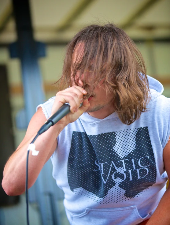 a man is singing into a microphone with his shirt open