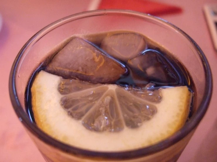 an iced drink with lemon slices, on a table