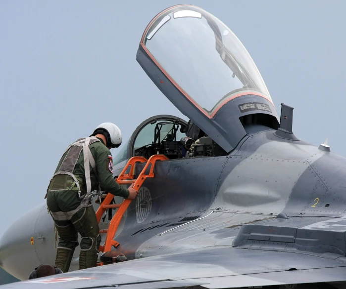 an airman is getting the front wing out of a fighter jet