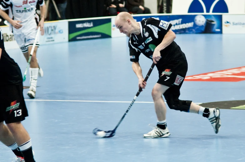 two men playing field hockey on a professional rink