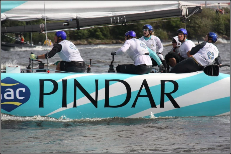 a team of people wearing helmets on the back of a blue boat in a river