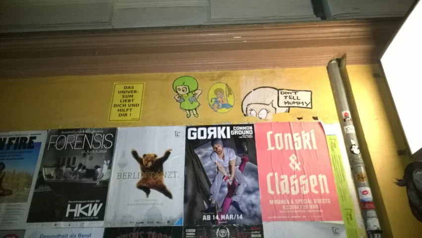 a wall with posters and some movies on it