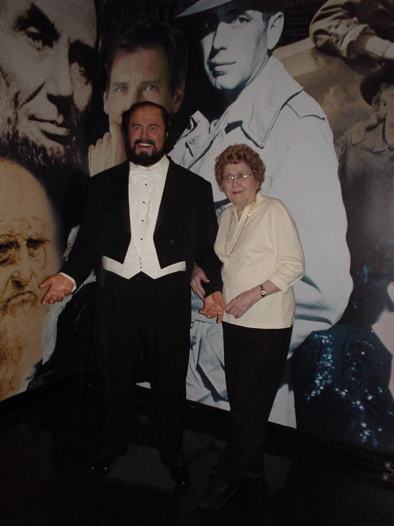 a man and woman posing next to a mural