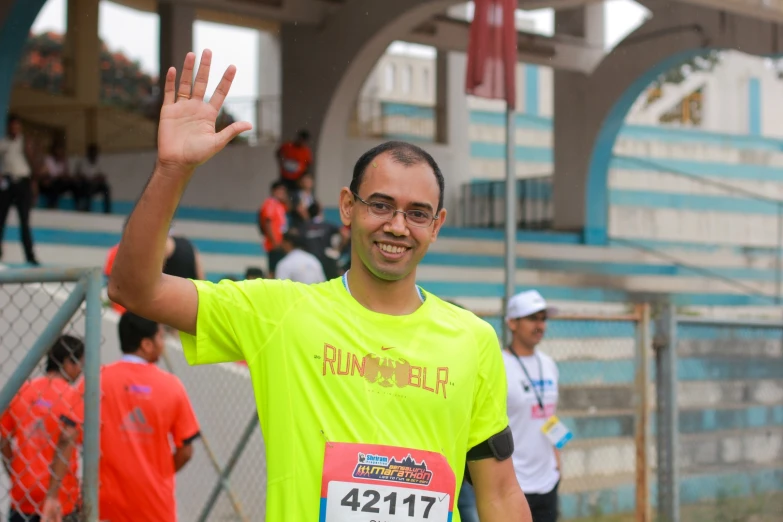 a man waves at the camera while running