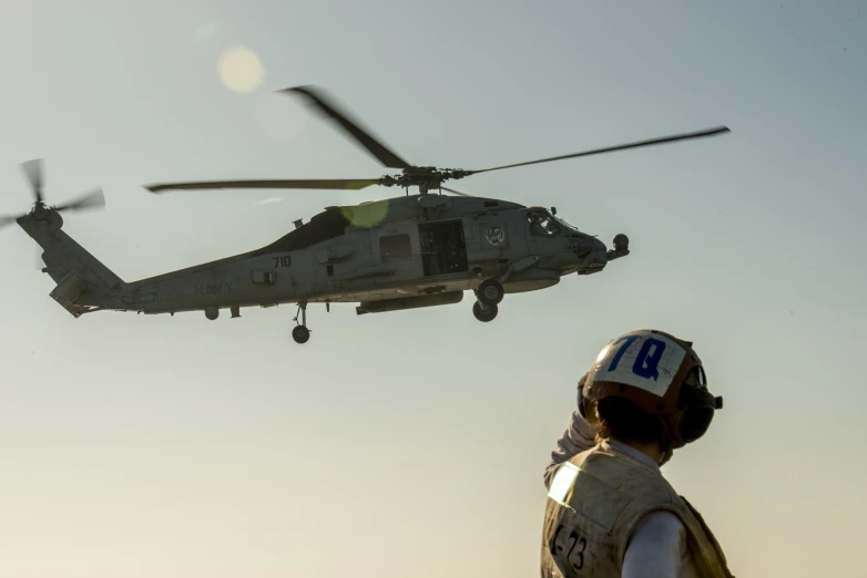 there is a helicopter flying above a person wearing a helmet