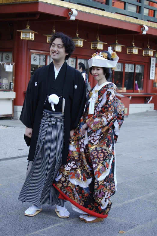 two people dressed in traditional japanese clothing and standing together