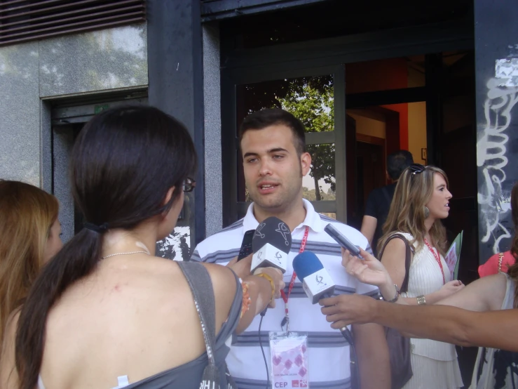 people standing around talking on microphones and standing in front of a doorway