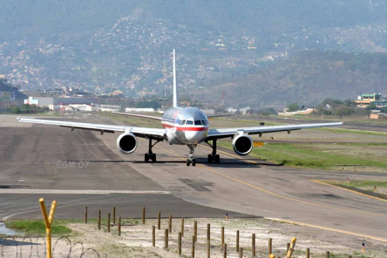 a commercial airplane sitting on an airstrip with another jet aircraft parked next to it