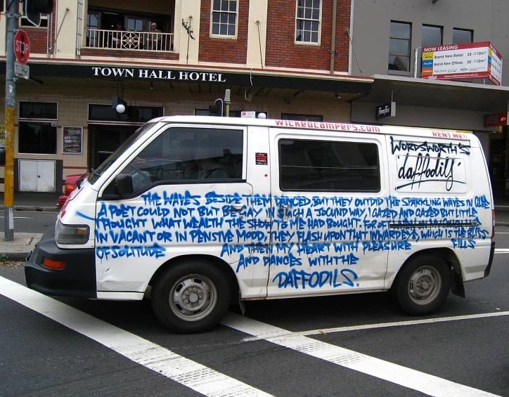 white van with writing on it is parked in front of a building