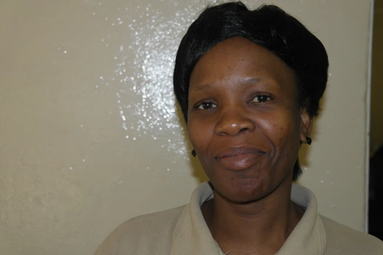 a woman wearing a white shirt smiles for the camera