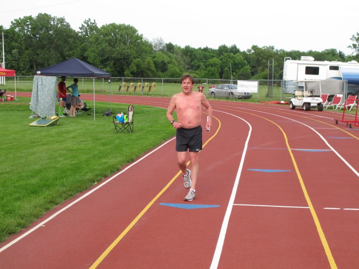 a man in blue shorts is running down the race track