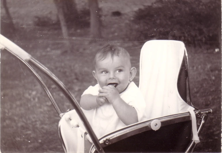 baby in a stroller eating food with his hands