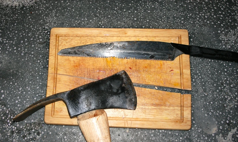 a black knife on top of a wooden  board
