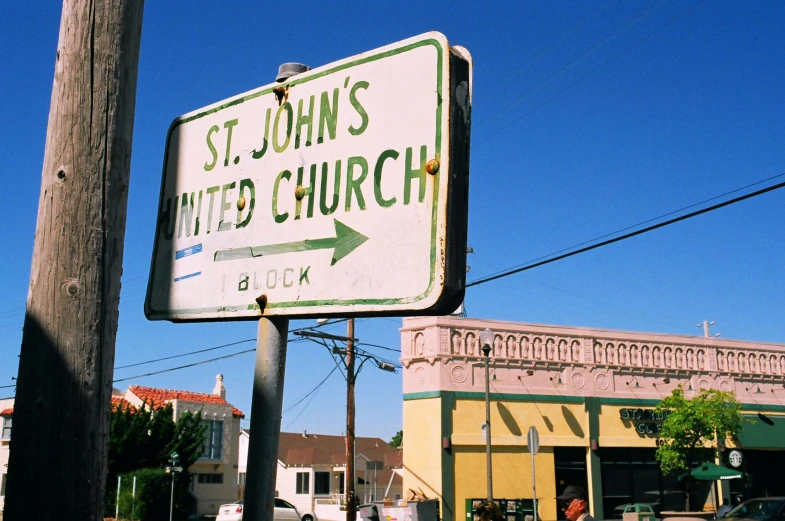 an old sign for st johns united church sits on the street