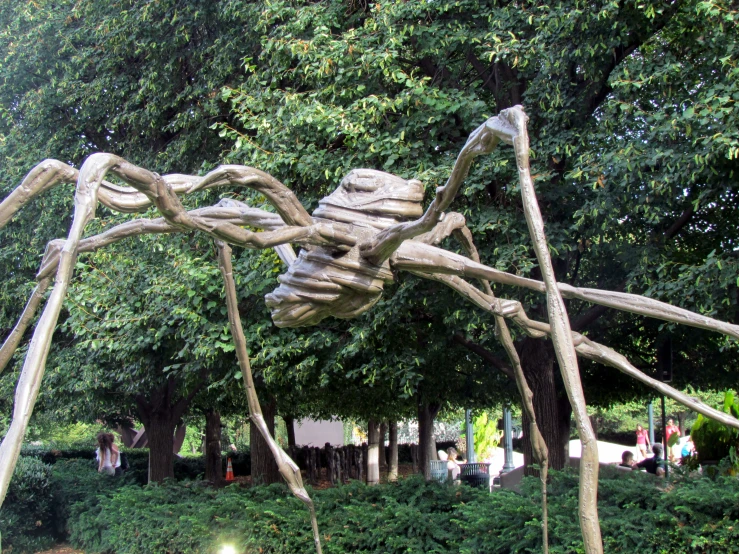 a spider statue in the middle of a park area